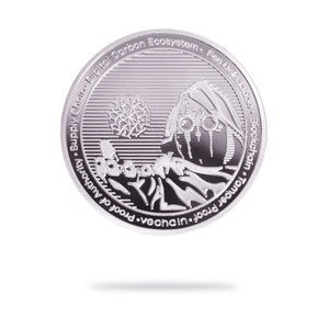 Puede incluir: Una moneda de plata con un diseño que presenta una imagen estilizada de una persona con un globo terráqueo y una cordillera. La moneda tiene texto alrededor del borde que dice "Supply Chain Digital Carbon Ecosystem. Fee Delegation. Blockchain. Tamper Proof. vechain. Proof of Authority."
