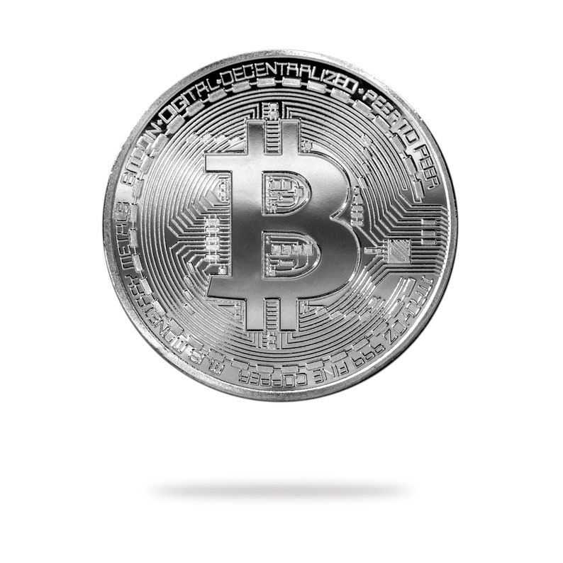 May include: A silver-colored Bitcoin coin with the Bitcoin symbol and the text "Bitcoin Digital Decentralized Peer-to-Peer" around the edge.