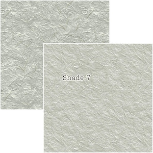 Puede incluir: Dos muestras de papel texturizado gris claro. La muestra m&aacute;s grande es una hoja completa, mientras que la m&aacute;s peque&ntilde;a es un primer plano con el texto "Shade 7". El papel tiene un aspecto arrugado con l&iacute;neas sutiles m&aacute;s oscuras.
