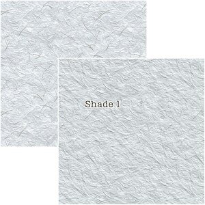 Puede incluir: Dos piezas rectangulares de papel texturizado gris claro con un patr&oacute;n sutil y org&aacute;nico. El texto "Shade 1" est&aacute; impreso en una de las piezas. El papel tiene una apariencia delicada y fibrosa, adecuado para manualidades o papeler&iacute;a.