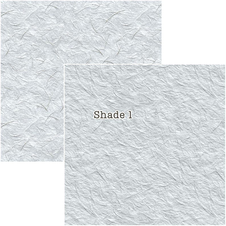 Puede incluir: Dos piezas rectangulares de papel texturizado gris claro con un patr&oacute;n sutil y org&aacute;nico. El texto "Shade 1" est&aacute; impreso en una de las piezas. El papel tiene una apariencia delicada y fibrosa, adecuado para manualidades o papeler&iacute;a.