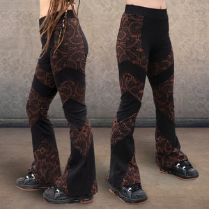 Puede incluir: Pantalón negro acampanado con estampado paisley marrón. El pantalón tiene cintura alta y pierna ancha.