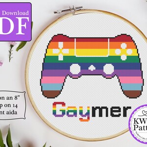 May include: A cross-stitch pattern featuring a rainbow-colored video game controller with the word "Gaymer" underneath. The pattern is designed to fit on an 8-inch hoop using 14-count Aida cloth.