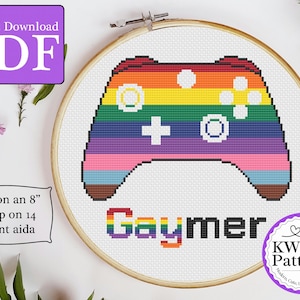 Op de afbeelding: Borduurpatroon voor een 20 cm hoepel met een regenboogkleurige videogamecontroller met het woord "Gaymer" in regenboogkleuren eronder. Het patroon is voor 14-count Aida-doek.