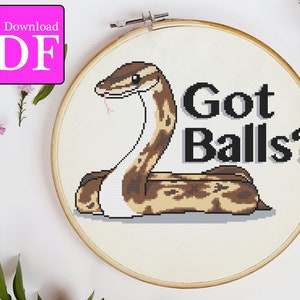 Peut inclure: Modèle de point de croix représentant un serpent avec le texte "Got Balls?" en lettres noires. Le serpent est brun et blanc avec une langue rose.