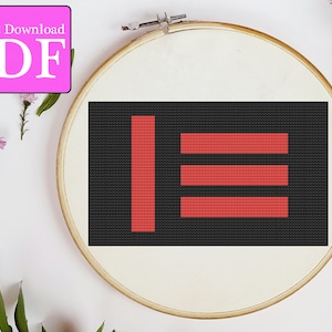 May include: A black and red cross stitch pattern with three horizontal red lines and a vertical red line. The pattern is in a wooden embroidery hoop.
