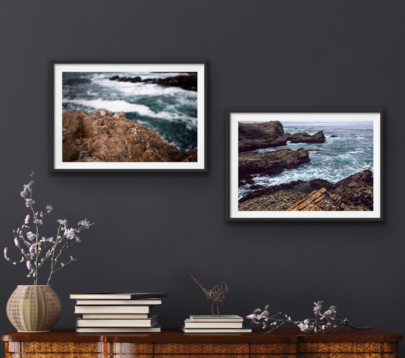 May include: Two framed photographs of ocean waves crashing against rocky shorelines. The top photo shows a close-up of the rocks and waves, while the bottom photo shows a wider view of the coastline.