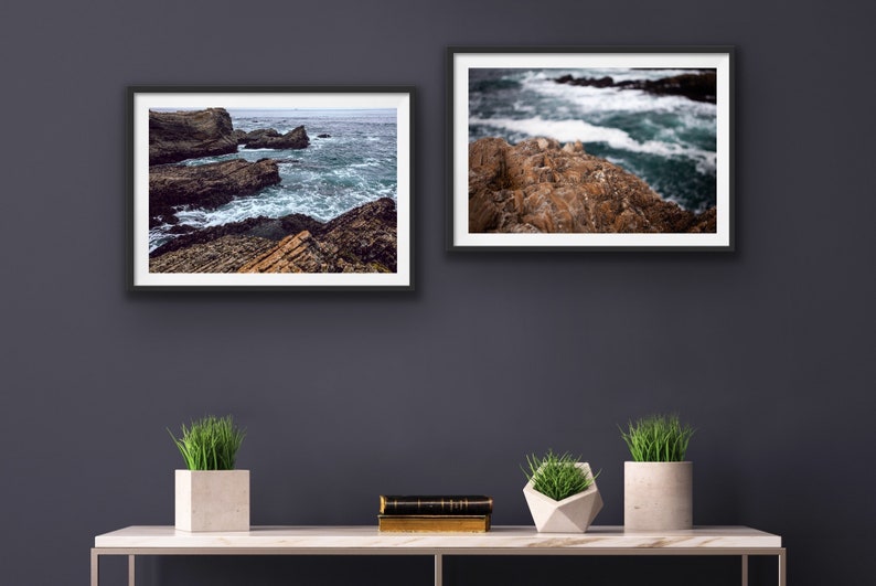 May include: Two framed photographs of a rocky coastline with crashing waves. The top photo shows a close-up of the rocks and waves, while the bottom photo shows a wider view of the coastline.