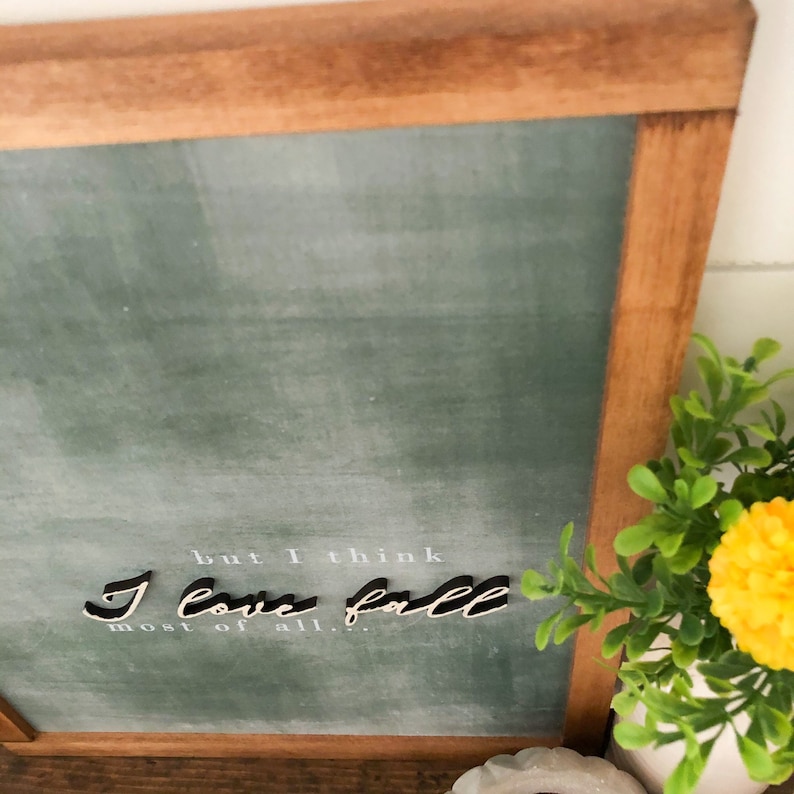 May include: A framed chalkboard sign with a green background and white text that reads "but I think I love fall most of all."