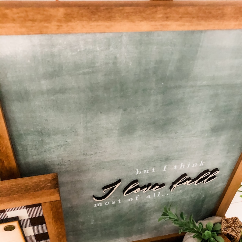 Peut inclure: Un panneau encadr&eacute; avec un fond vert vieilli et le texte "but I think I love fall most of all..." en noir et blanc. Le cadre est en bois brun clair.