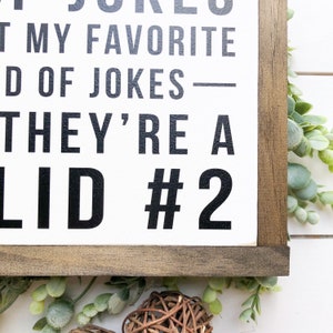 Puede incluir: Un letrero de madera blanco con texto negro que dice "Dad Jokes - They're a  #2  -  Not My Favorite Kind Of Jokes". El letrero est&aacute; enmarcado en un marco de madera marr&oacute;n oscuro.
