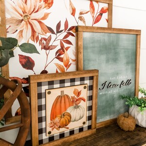Peut inclure: Plusieurs &oelig;uvres d'art encadr&eacute;es sur le th&egrave;me de l'automne. L'une pr&eacute;sente une illustration de citrouille sur un fond &agrave; carreaux noir et blanc. Une autre affiche le texte "but I think I love fall most of all..." sur un fond vert. Les pi&egrave;ces ont des cadres en bois.