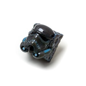 Op de afbeelding: Een zwarte en blauwe keramische toetsenkap in de vorm van een Star Wars Stormtrooper-helm.