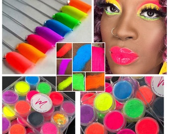 May include: A set of 12 neon pigment powders in a clear plastic container. The powders are in various colors, including yellow, green, blue, orange, pink, and purple. The container has a black label with the text "Miracle Cosmetics" and "Your Beauty One Stop Shop".