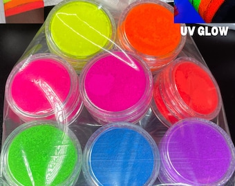 May include: A collection of seven neon pigment jars in a clear plastic bag. The jars contain bright colors including yellow, orange, pink, red, green, blue, and purple. The text "NEON PIGMENTS" is at the bottom of the image, and "UV GLOW" is in the upper right corner.