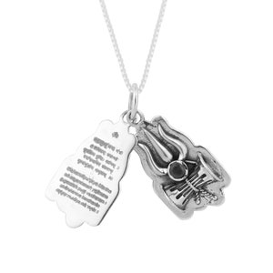 May include: A silver pendant necklace featuring a detailed religious symbol with a trident design and a small, dark gemstone. The pendant has an openable, rectangular charm with engraved text. The necklace chain is a delicate silver.