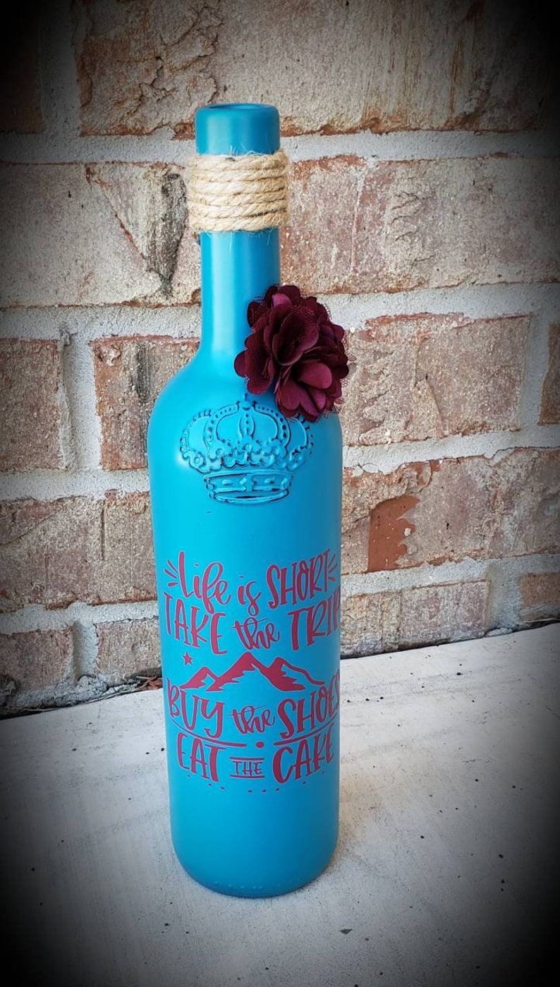 Custom painted wine bottle decor made from repurposed bottles perfect for wedding decor.