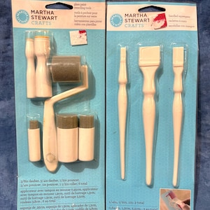 Könnte beinhalten: Zwei Martha Stewart Crafts Glasmalerei-Schablonen-Werkzeug-Sets. Ein Set enthält Tupfer, Pouncer und eine Rolle. Das andere Set enthält Handabzieher. Die Werkzeuge sind weiß.