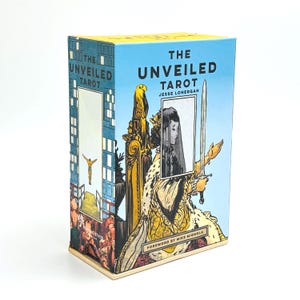 May include: A tarot card box titled "The Unveiled Tarot" by Jesse Lonergan. The box features illustrations of a woman holding a sword, an eagle, and architectural elements. The box has a blue and yellow color scheme.