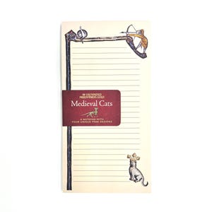 May include: A cream-coloured lined notepad featuring a dark red paper band with the text The Unemployed Philosophers Guild Medieval Cats A Notepad With Four Unique Page Designs. The notepad has illustrations of cats in medieval attire.