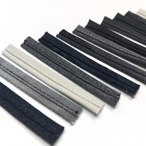 Puede incluir: Una colección de 14 diferentes tonos de ribete de mezclilla gris, que van desde el gris claro hasta el gris oscuro.