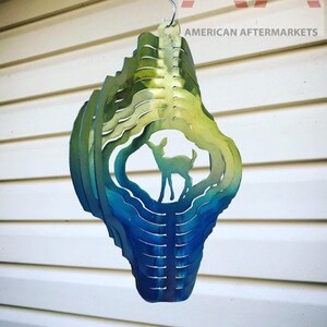 May include: A metal wind spinner with a deer silhouette in the center. The spinner has a gradient of green, blue, and yellow colors.