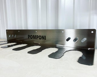 May include: A stainless steel wall-mounted gun rack with six slots and the word "POMPONI" engraved on the front.