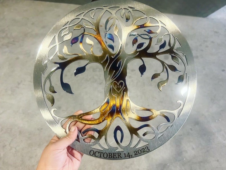 Peut inclure: Une &oelig;uvre d'art murale en m&eacute;tal repr&eacute;sentant un arbre de vie avec une finition brune, bleue et dor&eacute;e. L'arbre a des branches et des feuilles complexes. Les racines sont visibles au bas de l'arbre. La date "OCTOBER 14, 2023" est inscrite au bas de l'&oelig;uvre d'art.
