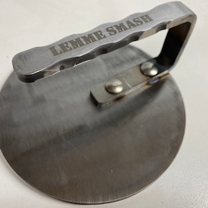 May include: A silver metal burger smasher with a handle that says "LEMME SMASH".