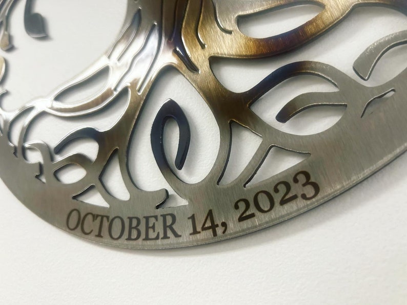 Peut inclure: Une d&eacute;coration en m&eacute;tal en forme d'arbre de vie avec un motif d&eacute;coup&eacute; et la date "OCTOBER 14, 2023" grav&eacute;e sur le bas.