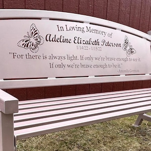 Puede incluir: Un banco de metal rosa con una inscripci&oacute;n conmemorativa. La inscripci&oacute;n dice: "In Loving Memory of Adeline Elizabeth Peterson 1/14/22-1/15/22" e incluye una cita de Amanda Gorman: "Porque siempre hay luz. Si solo somos lo suficientemente valientes para verla. Si solo somos lo suficientemente valientes para serla."