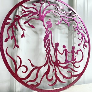 Puede incluir: Una pieza de arte de pared de metal rosa que representa un &aacute;rbol de la vida estilizado con una madre y tres hijos tomados de la mano. El &aacute;rbol tiene ramas y ra&iacute;ces intrincadas.