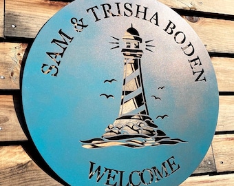 May include: A blue metal round sign with a lighthouse silhouette and the text "Sam & Trisha Boden" and "Welcome".