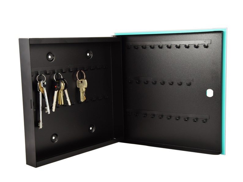 May include: A black metal key holder with a turquoise door. The key holder has 30 hooks and is open to reveal several keys hanging on the hooks.