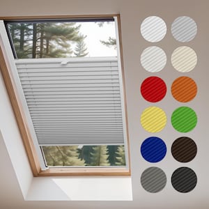 May include: A gray pleated window shade is installed in a wooden-framed skylight. The shade is partially lowered, revealing a view of trees. A color chart displays various round fabric swatches in shades of white, gray, red, orange, yellow, green, blue, brown, and black.