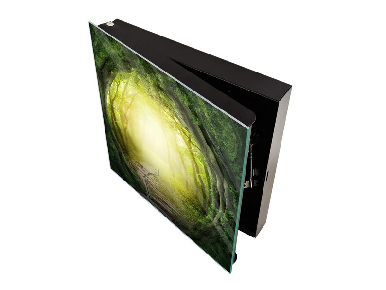 May include: A black framed picture with a green and yellow forest scene. The picture is open and the frame is visible.