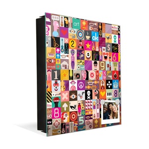 Puede incluir: Un colorido tablero magn&eacute;tico montado en la pared con un collage de gr&aacute;ficos de arte pop, n&uacute;meros y s&iacute;mbolos. Una peque&ntilde;a foto est&aacute; adjunta al tablero. El tablero es rectangular y tiene un marco negro.