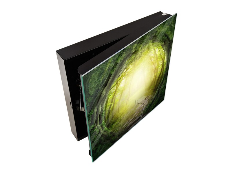 May include: A black framed wall art piece with a green and yellow image of a path through a forest. The image is printed on glass and the frame is open on one side.