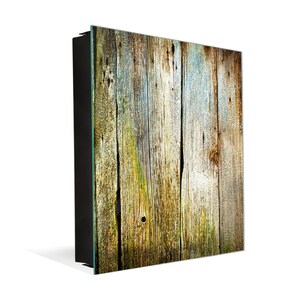 May include: A close-up of a weathered wooden wall with a variety of shades of brown, green, and blue. The wood is arranged in vertical planks, and the surface is rough and textured.