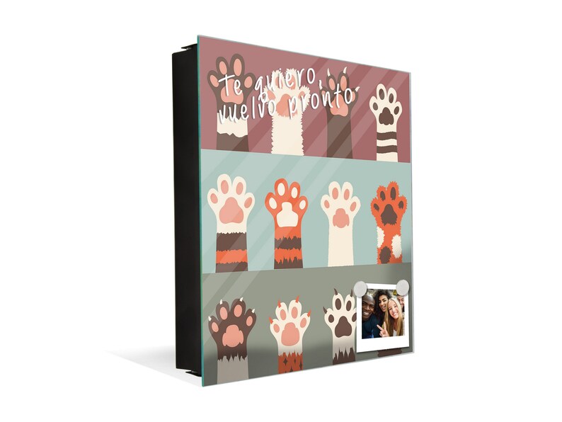 May include: A square glass sign with a black frame featuring a colorful paw print design. The sign has the text "Te quiero, vuelvo pronto" in white lettering. A photo of two people is attached to the sign with magnets.