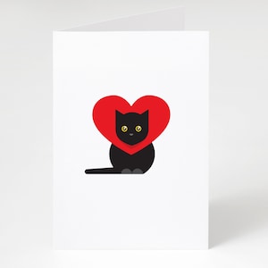 May include: A white greeting card with a black cat wearing a red heart. The cat has yellow eyes and is sitting with its tail to the left. The design is simple and graphic, suitable for Valentine's Day or a similar occasion.