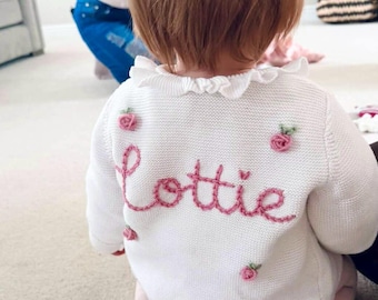 Cárdigan de bebé personalizado con volantes, nombre y rosas.