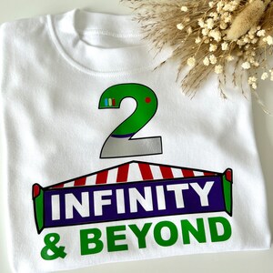 May include: White t-shirt with a green number 2, a red and white striped awning, and the text "INFINITY & BEYOND" in purple and green.