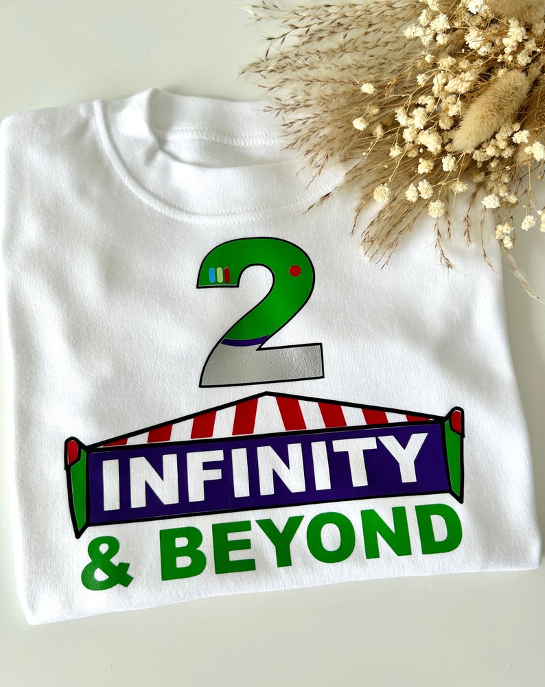 May include: White t-shirt with a green number 2, a red and white striped awning, and the text "INFINITY & BEYOND" in purple and green.