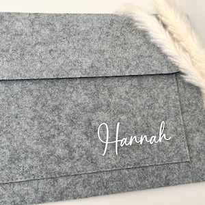 May include: A grey felt envelope with the name "Hannah" written in white cursive lettering.