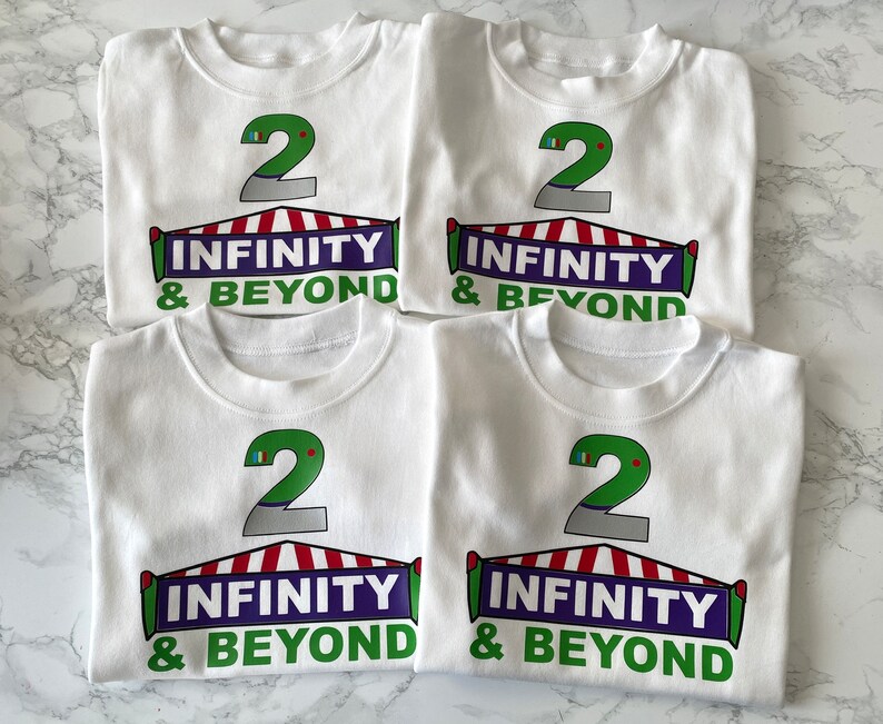 May include: Four white t-shirts with a green number 2, a red and white striped tent, and the text "INFINITY & BEYOND" printed on each shirt.