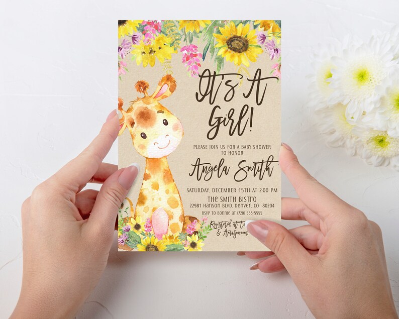May include: A baby shower invitation with a cute cartoon giraffe illustration. The invitation is decorated with sunflowers and other flowers. The text on the invitation reads "It's a Girl!" and includes the name "Angela Smith", the date and time of the shower, and the location.