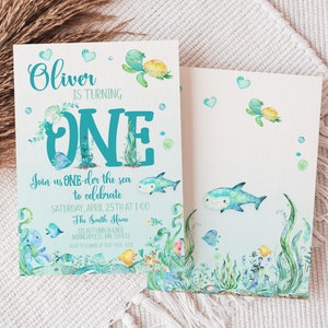 Peut inclure: Une carte d'invitation bleue et verte avec une illustration aquarelle d'une tortue de mer, d'un requin et d'autres cr&eacute;atures marines. Le texte sur la carte indique "Oliver a un an. Rejoignez-nous pour f&ecirc;ter &ccedil;a le samedi 25 avril &agrave; 13h00 chez les Smith 111 Autumn Avenue Minneapolis, MN 55432 RSVP au [num&eacute;ro de t&eacute;l&eacute;phone]"