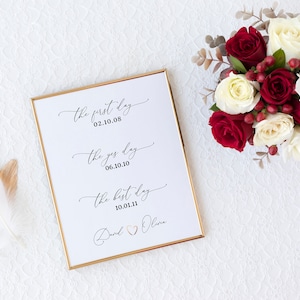 May include: A white framed print with gold trim featuring the text "the first day 02.10.08", "the yes day 06.10.10", and "the best day 10.01.11" with the names "David & Olivia" at the bottom.