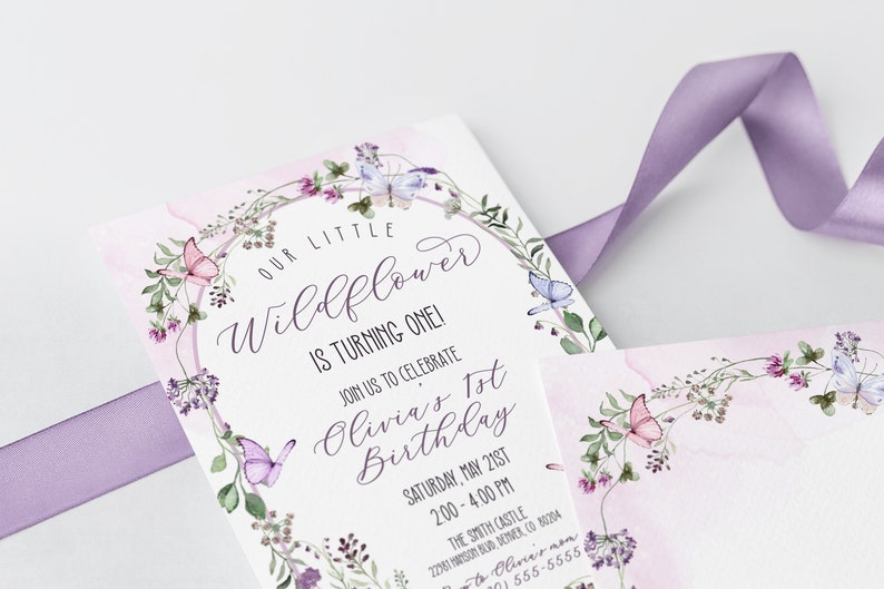 May include: A white invitation card with a watercolor floral wreath and butterflies. The text reads "Our Little Wildflower is Turning One! Join us to celebrate Olivia's 1st Birthday, Saturday, May 21st, 2:00 - 4:00 PM, The Smith Castle, 2201 Windsor Rd, Denver, CO 80204, RSVP to Olivia's mom (555) 555-5555".